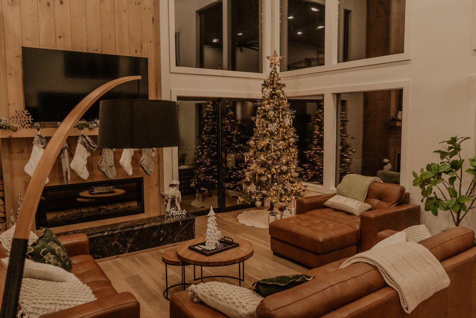 Gemütliches Wohnzimmer mit geschmücktem Weihnachtsbaum, Kamin und Kuscheldecken
