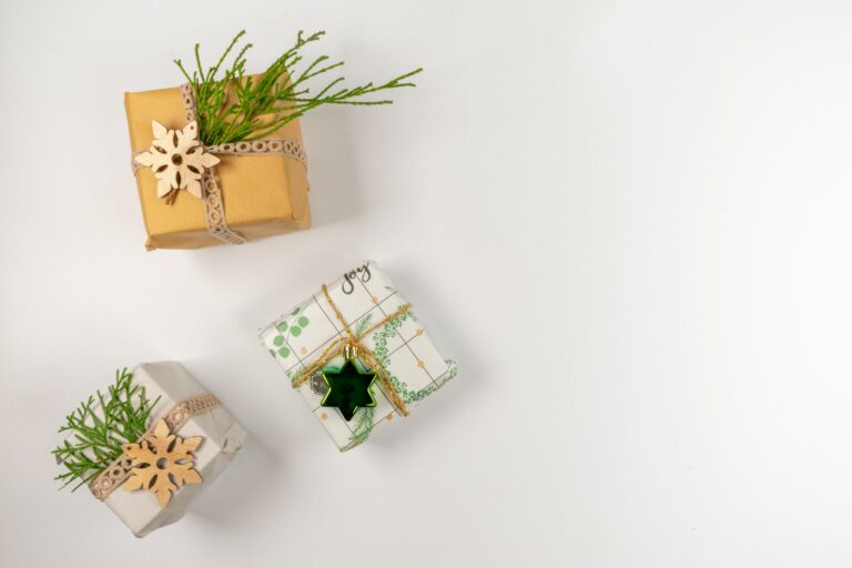 Drei kleine, natürlich verpackte Weihnachtsgeschenke mit Tannengrün und Holzsternen